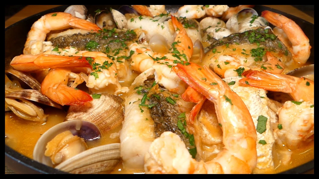 Merluza a la marinera acompañada de langostinos