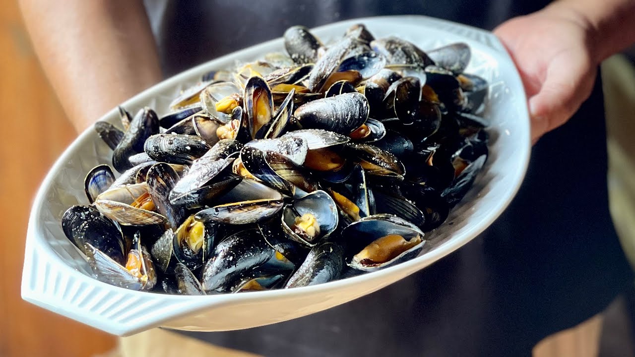 Cocinando mejillones de roca en la sartén